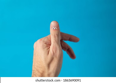 Creative Concept, Male Nail, With Eyes And Fingers. On A Blue Background