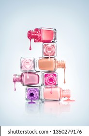 Creative concept photo of beauty product nail polish dripping from stacked bottles on white background. - Shutterstock ID 1350279176