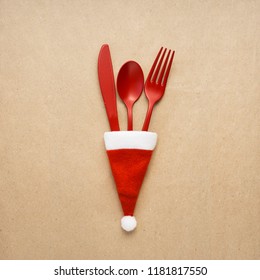 Creative Concept Photo Of Tableware Christmas Hat In On Brown Background.