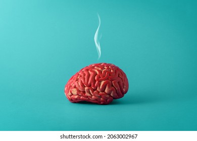Creative concept of a tired brain on a blue background. Human brain with smoke.   