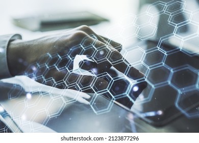 Creative concept of wireless technology with hexagon hologram and finger clicks on a digital tablet on background. Big data and database concept. Multiexposure