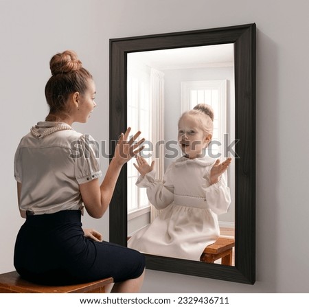 Creative conceptual collage. Excited young girl looking in mirror and seeing reflection of little girl, her child self. Concept of present, past and future, age, lifestyle, memories, generation, ad