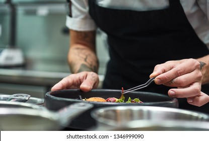 Creative Cooking. Cropped image of chef hands garnishing Pasta carbonara in a restaurant kitchen. - Powered by Shutterstock