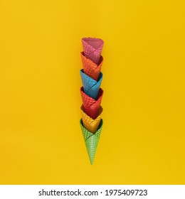 creative decoration made with colorful ice crem cone on the yellow illuminating summer sunny background creative abstract art. minimal background with copy space