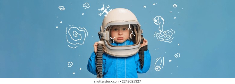 Creative design with drawn elements. Portrait of little boy, child in costume of astronaut over blue background. Feeling sad. Concept of imagination, childhood, creativity, dreams, ad