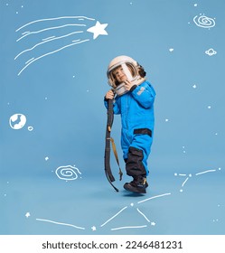 Creative design with drawn elements. Portrait of little boy, child in costume of astronaut over blue background. Playful kid. Concept of imagination, childhood, creativity, dreams, ad
