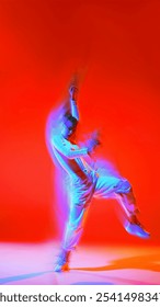 Creative design. Powerful and dynamic dance of young girl in motion, dancing hip hop against red background with intense light effect. Concept of dance, art, modern style, youth culture