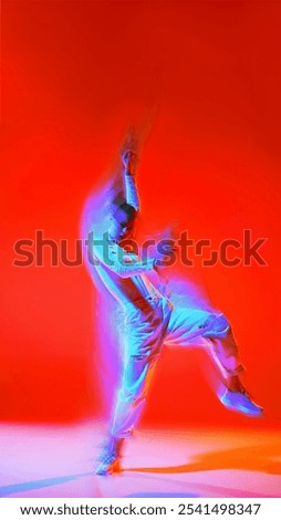 Creative design. Powerful and dynamic dance of young girl in motion, dancing hip hop against red background with intense light effect. Concept of dance, art, modern style, youth culture