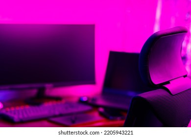 Creative Designer's Workplace, Back View. Office Chair And Work Desk View With Graphic Tablet, Computer And Smartphone. Retoucher Home Office In Neon Pink Blue