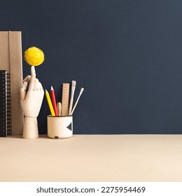 Creative desk and blank picture frame poster  desk objects  office supplies  books dark blue background 	
