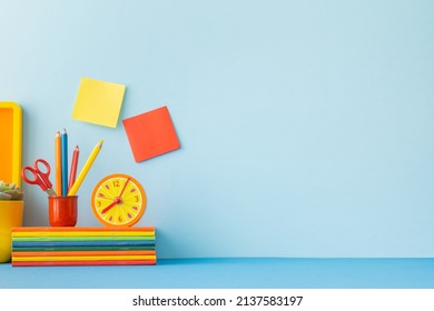 Creative Desk In Kids Room With Yellow Frame Mock Up, Plant And Notebooks, Note On The Wall And Many Yellow And Orange Supplies.