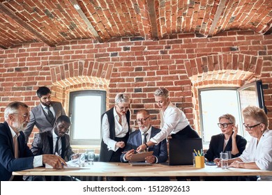 Creative Director invited caucasian blonde adult man wear blue suit sit table and listen ideas. Employees discuss, correst and make notice regarding new project - Shutterstock ID 1512892613