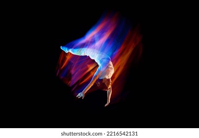 Creative dynamic portrait of athlete, dancer in white sports clothes jumping, flying over dark background in mixed neon light, glow. Art, aspiration, music, fashion. Copy space for ad