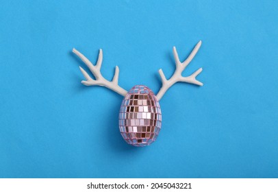 Creative Easter Layout. Mirror Egg With Antlers On Blue Background. Party Concept