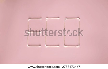 Creative eco concept made with reusable bamboo cotton swabs forming the word “ECO” on a pastel pink background. Minimal flat lay composition symbolizing sustainability, zero waste lifestyle, environmentally friendly personal care, and plastic-free alternatives. Modern aesthetic with natural materials and clean design.