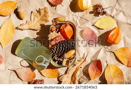 Creative fall composition with tin can filled with natural autumn leaves and elements. Autumnal season.