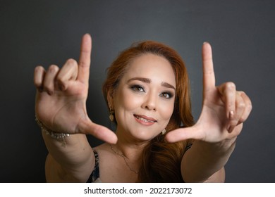 Creative And Fashion Portrait Of Mature White Hispanic Woman Framing Her Face With Her Hands