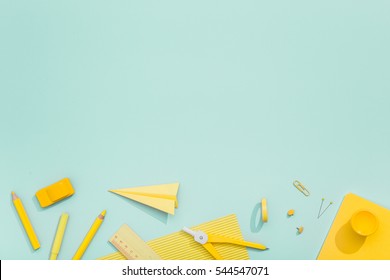 Creative, fashionable, minimalistic, school or office workspace with yellow supplies on cyan background. Flat lay.