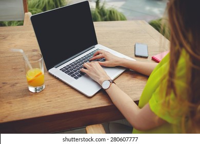 Creative female freelancer sitting front laptop computer with blank copy space screen for your information, young business woman work on notebook typing text during breakfast in modern coffee shop - Powered by Shutterstock