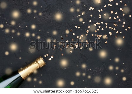 Creative flat lay composition with bottle of champagne and space for text on color background.  New year celebration party concept