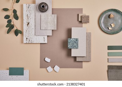Creative flat lay composition of interior designer moodboard with textile and paint samples, panels and cement tiles. Beige, grey and green color palette. Copy space. Template. 