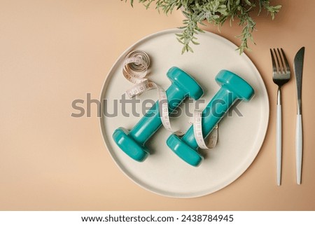 Creative flat lay composition with plate, fork, knife, dumbbell and measuring tape on pink background. Intermittent fasting, ketogenic, diet concept. top view, copy space.