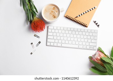 Creative flat lay composition with tropical flowers, stationery and computer keyboard on white background - Shutterstock ID 1140612392