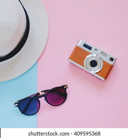 Creative Flat Lay Fashion Style With Camera, Sunglasses And Panama Hat On Pastel Color Background