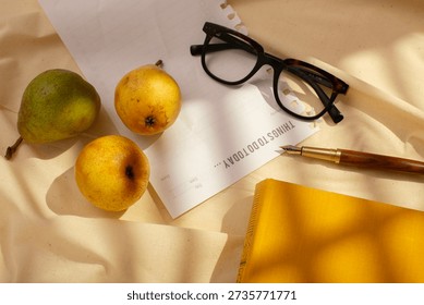 Creative flat lay of fresh pears, planner page, pen and glasses, illuminated by soft natural light