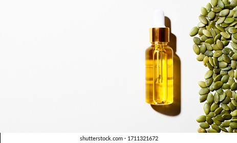 Creative Flat Lay Of Glass Bottle With Organic Natural Pumpkin Seed Oil Extract Cosmetics For Skin And Hair Care.Minimal Beauty Spa Treatment Medical Products Concept.Horizontal Orientation,copy Space