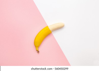 Creative Flat Lay Of A Half Peeled Banana On A Pink And White Background, Top View