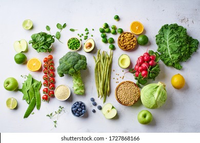 Creative flat lay with healthy vegetarian meal ingredients. Raw food concept. A variety of organic fruits, nuts, berries and vegetables with avocado. Vegan menu