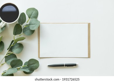 Creative Flat Lay Photo Of Workspace Desk. Top View Office Desk With Mock Up White Paper, Coffee, Pen, Plant Branches On White Background. Workspace Concept. Top View, Copy Space, Mockup, Flat Lay.