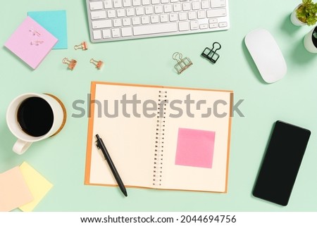 Creative flat lay photo of workspace desk. Top view office desk with keyboard, mouse and open mockup black notebook on pastel green color background. Top view mock up with copy space photography.