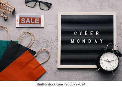 Creative flat lay promotion composition Cyber Monday sale text on letter board with alarm clock goodie bag and gadget