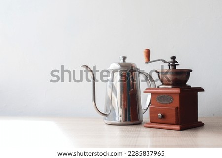 Creative flat lay of wood table and minimalist room with a coffee grinder and pot. Landscape top view copy space.