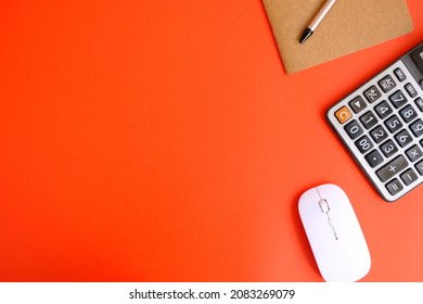 Creative flat lay of workspace desk with laptop, caculator and notebook on red colour background. Business, Insurance or money concept