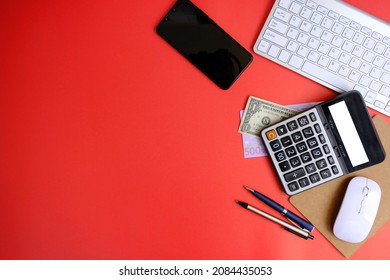 Creative flat lay of workspace desk with laptop, caculator and notebook on red colour background. Business, Insurance or money concept