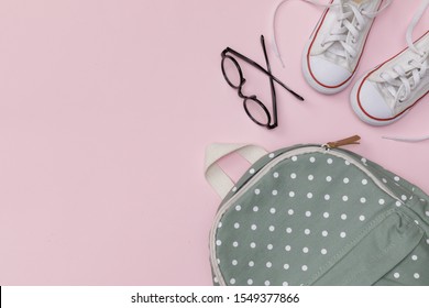 Creative Flatlay Of Education Pink Table With Backpack, Shoes,  Eye Glasses, Empty Space Isolated On Pink Background, Concept Of Education And Back To School