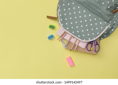 Creative Flatlay Of Education Yellow Table With Backpack, Student Books, Colorful Pencil, Empty Space Isolated On Yellow Background, Concept Of Education And Back To School