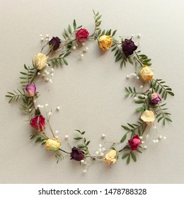Creative floral background. Colorful flowers circle composition on beige background. Wreath with red and yellow dried roses and herbs. - Shutterstock ID 1478788328