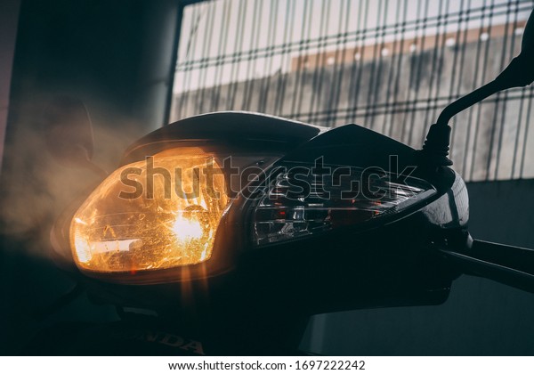 Creative\
foggy shot of motorbike / scooter\
headlight