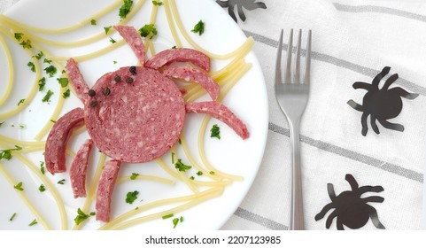 Creative Food, Kids Food. A Sausage Spider Sits On A Web Of Spaghetti On A White Plate. Top View. Halloween Food Idea