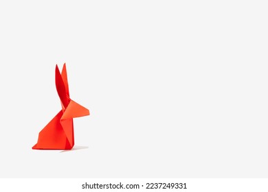 Creative greeting card design made of red paper rabbit on a white background. Lunar New Year composition for 2023. Year of the Rabbit.