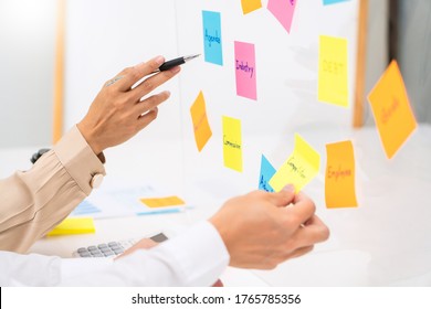 Creative group of business people brainstorming use sticky notes to share idea on glass window or table in office - Shutterstock ID 1765785356