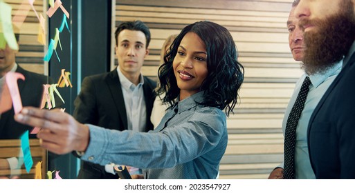 Creative group of business people brainstorming putting sticky notes on glass wall in office - Shutterstock ID 2023547927