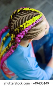 creative hairstyle of thin and thick plaits with interweaving neon hair kanekalon, girl with a creative hairstyle from African braids