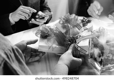 Creative Hand using smart phone and co business worker choosing gift at office party,on marble meeting table,filter film effect