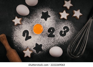 Creative Happy New Year 2023 greeting card for home baker. Numbers made out of flour with egg yolk, Christmas baking concept, top view