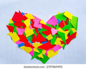 Creative heart shape composed of various colorful paper scraps on a white background. Concept of love, diversity, celebration, craft, and mosaic pattern. 